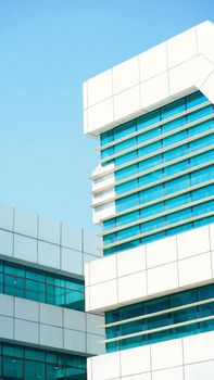 Vibrant modern building showcasing blue glass and white geometric design under clear sky.