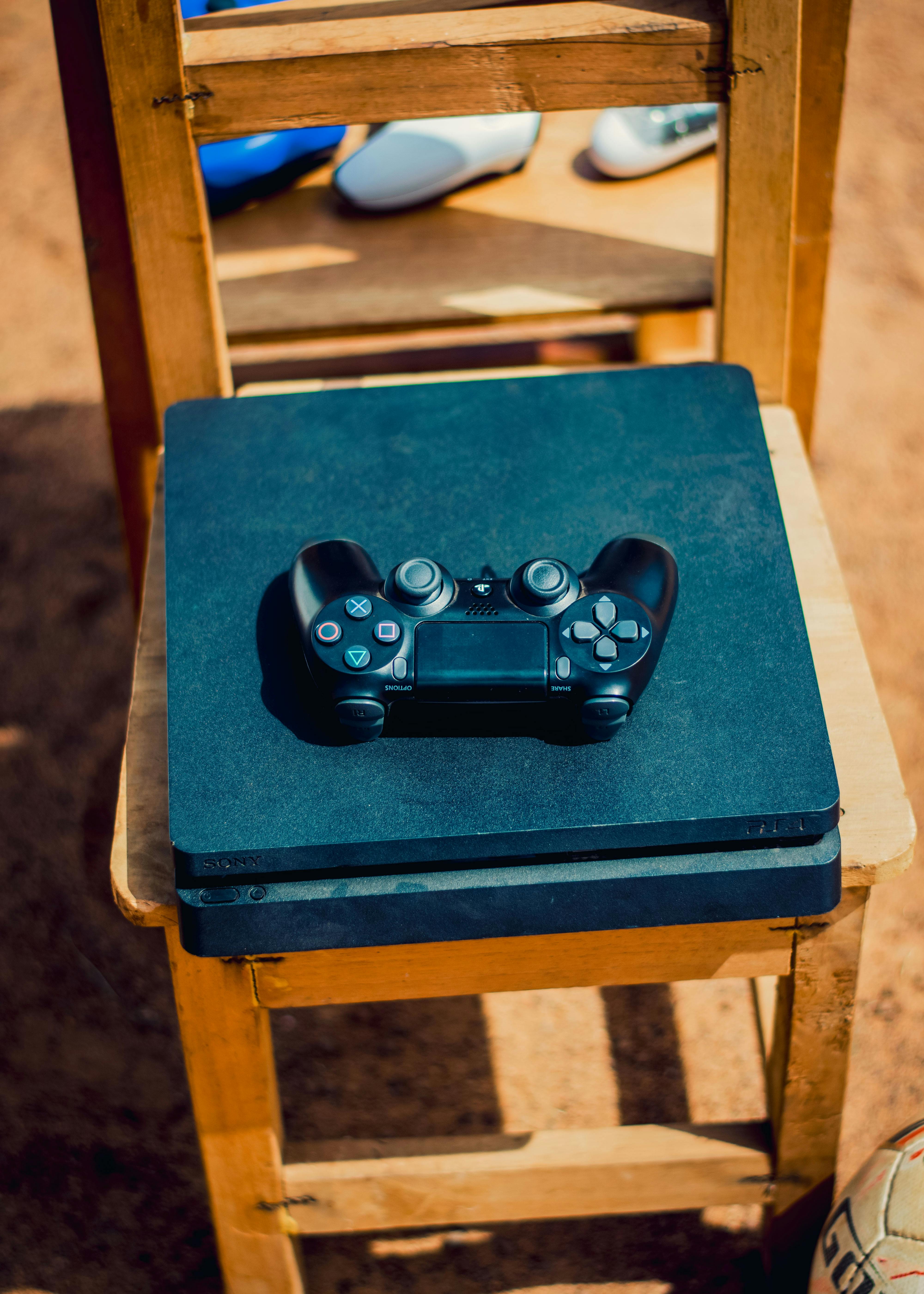 game console and controller on wooden chair outdoors