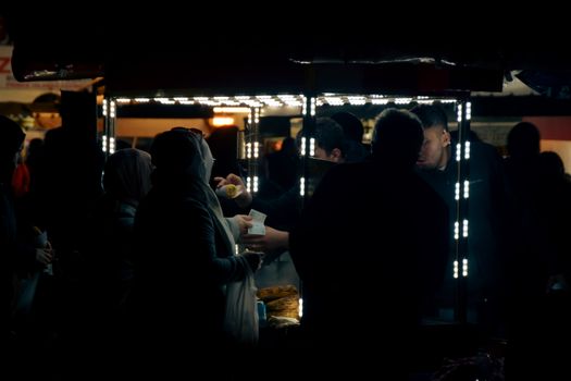 Crowd gathering at a street food stall in Istanbul at night.