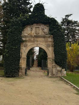 Ivy-clad historic stone archway in a garden setting.