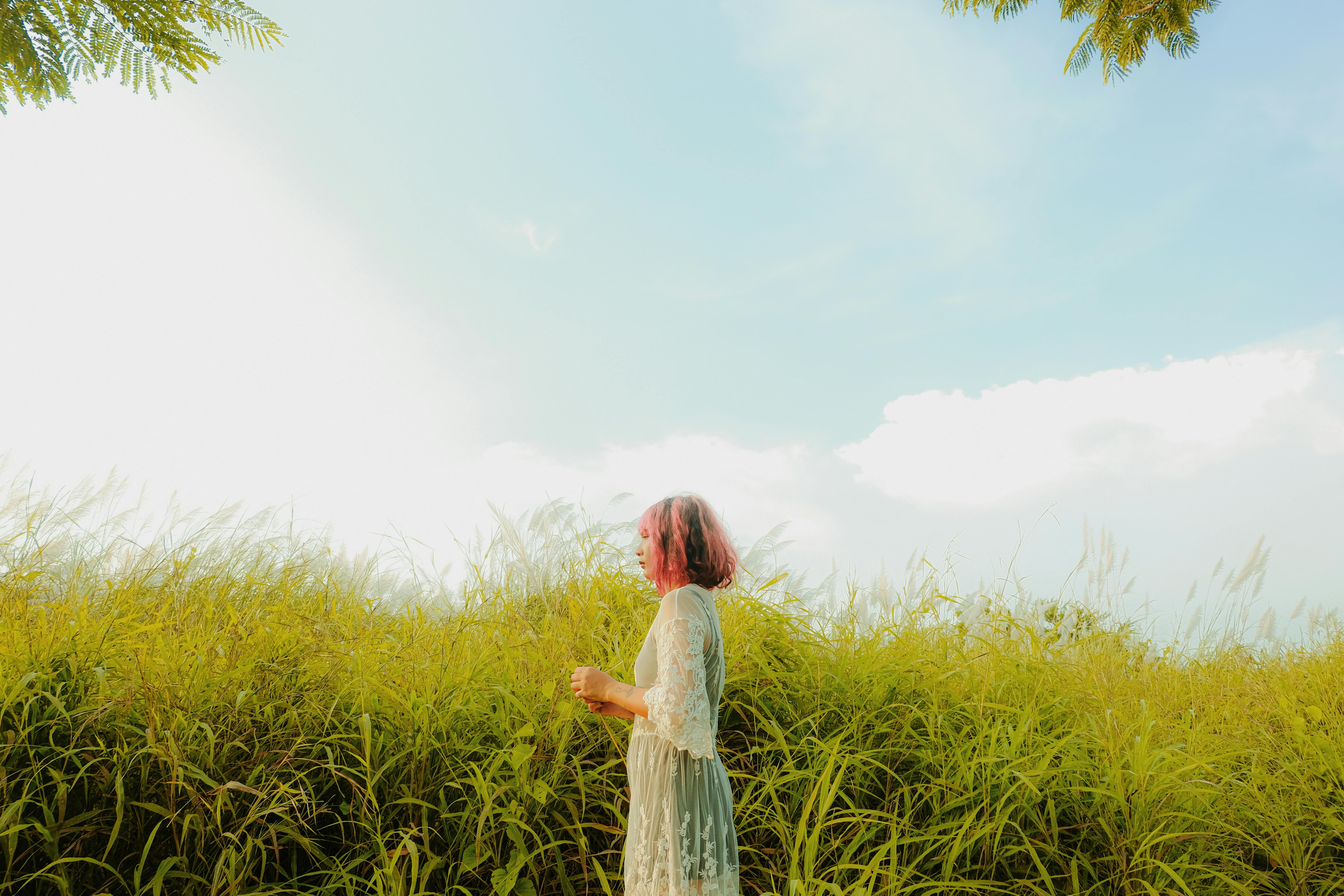 夏日天空下，一个女人在郁郁葱葱的草地上享受着宁静的时刻