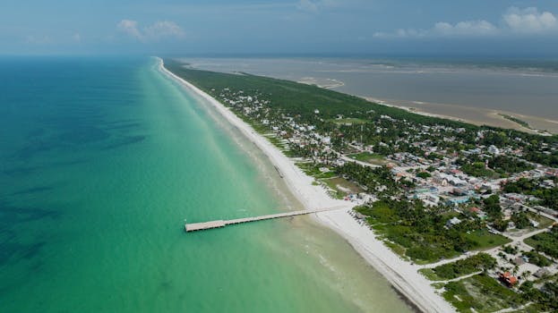 Stunning aerial view of El Cuyo Beach with turquoise waters and lush coastline in Yucatan, Mexico.