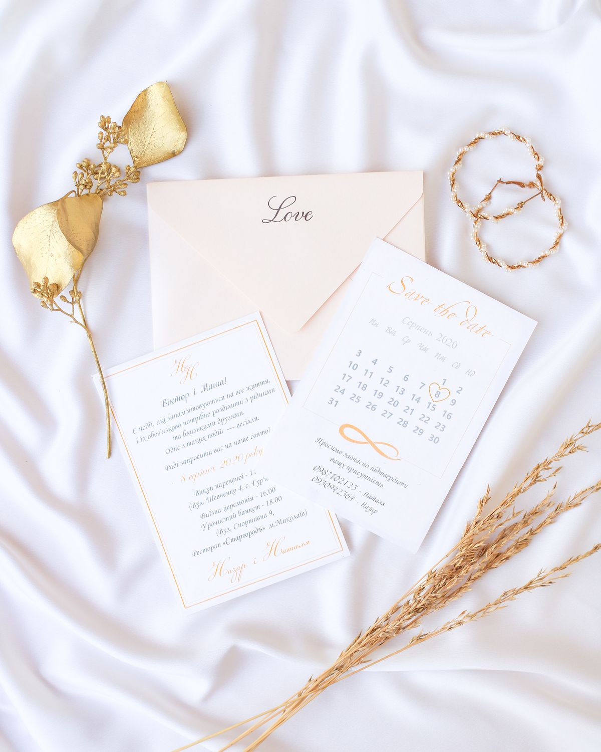 Elegant wedding invitation stationery arranged on white fabric