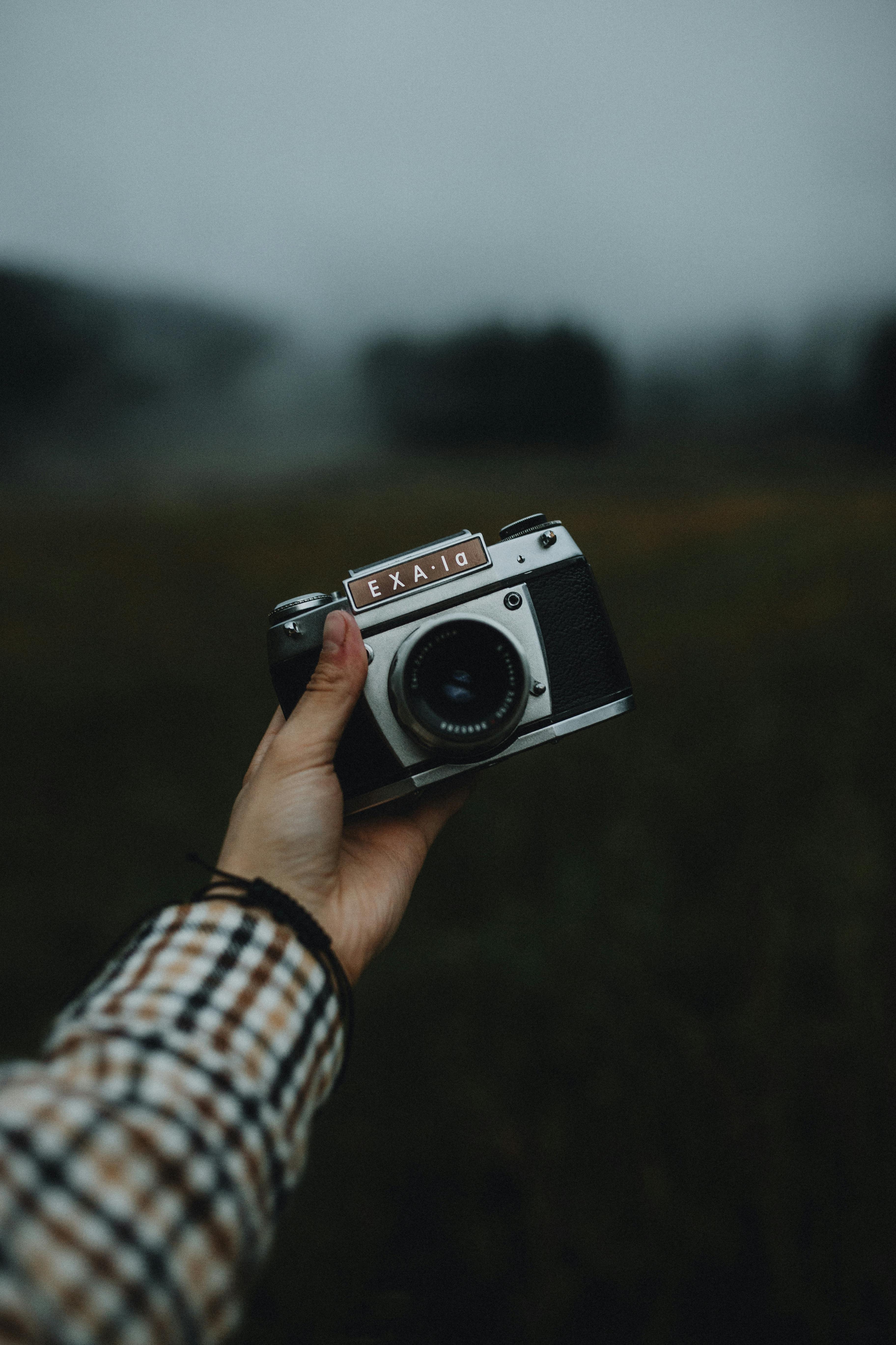 Capture of a vintage camera held outdoors in a foggy, moody environment in Slovakia.