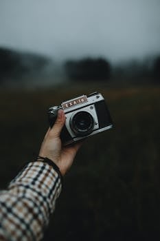 Capture of a vintage camera held outdoors in a foggy, moody environment in Slovakia.