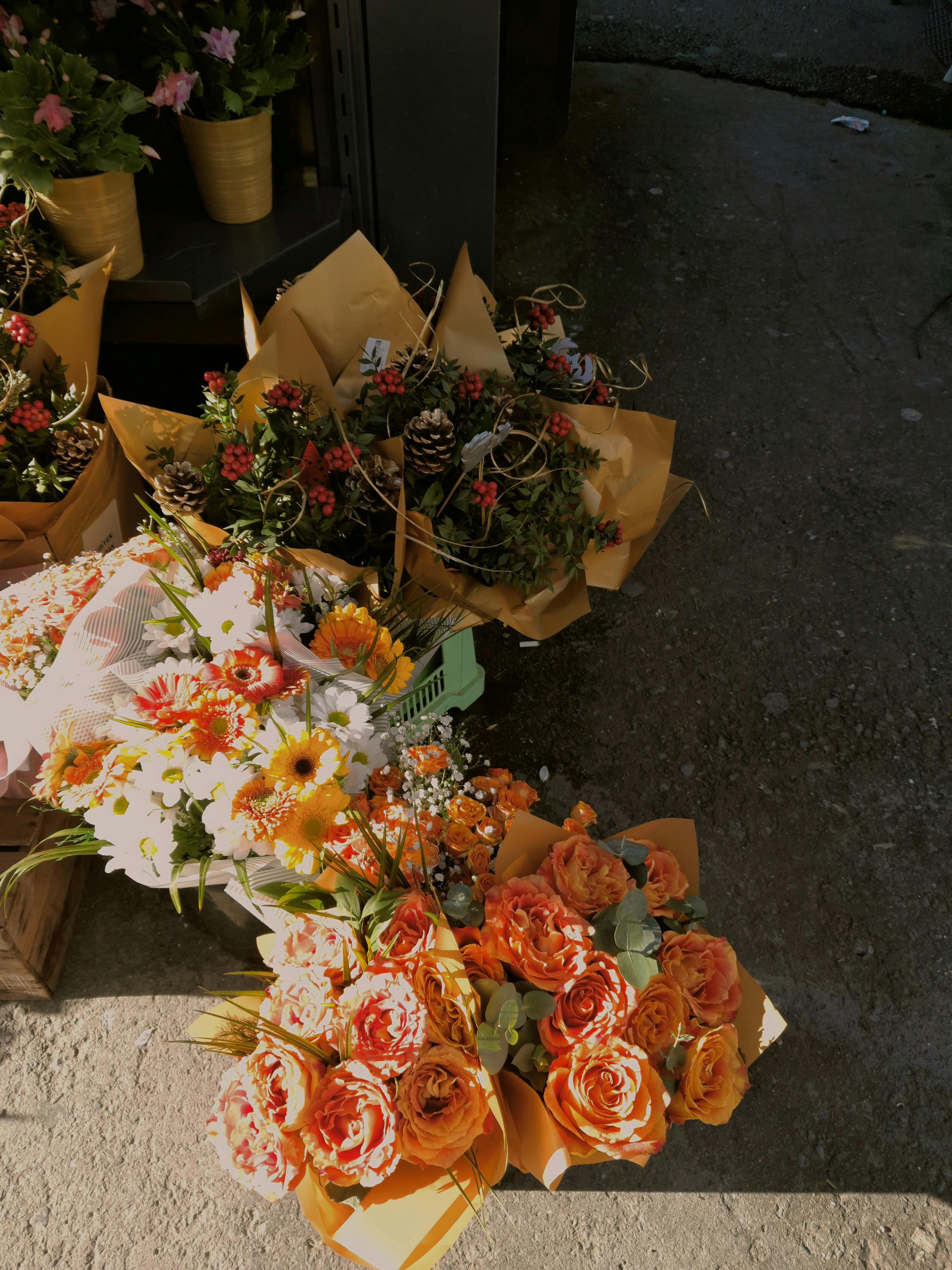 Elegant floral bouquets with roses and daisies in warm sunlight.