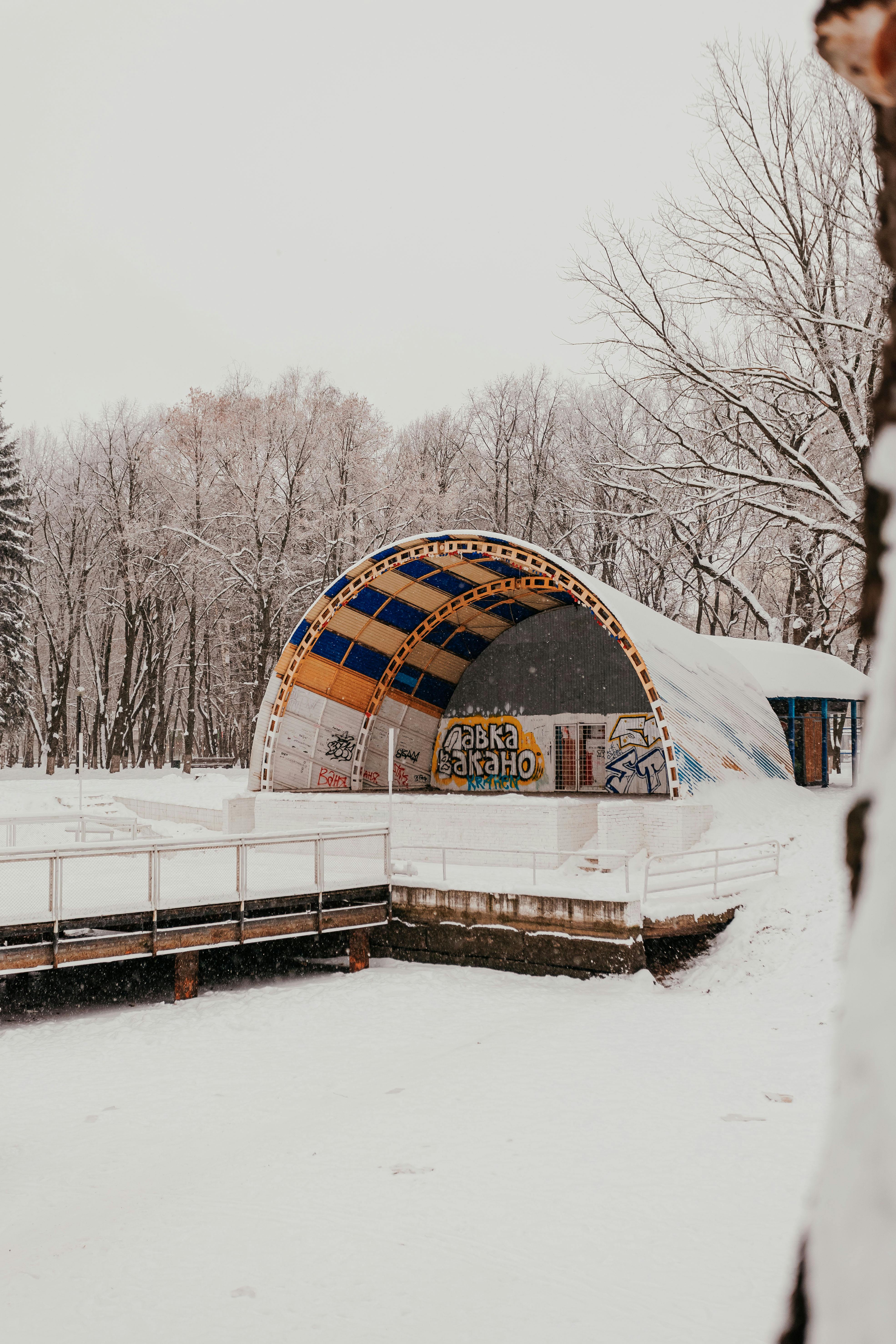Free A snow-covered outdoor amphitheater surrounded by bare winter trees. Stock Photo