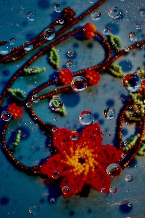 Free Vibrant beaded necklace with water droplets on a blue background for unique design. Stock Photo