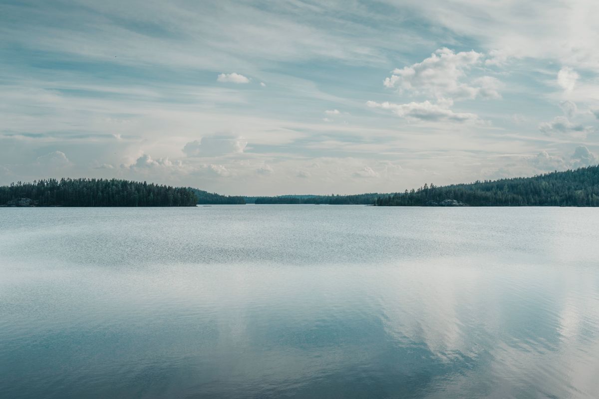 Priveliște de lac în Finlanda, sub cer înnorat