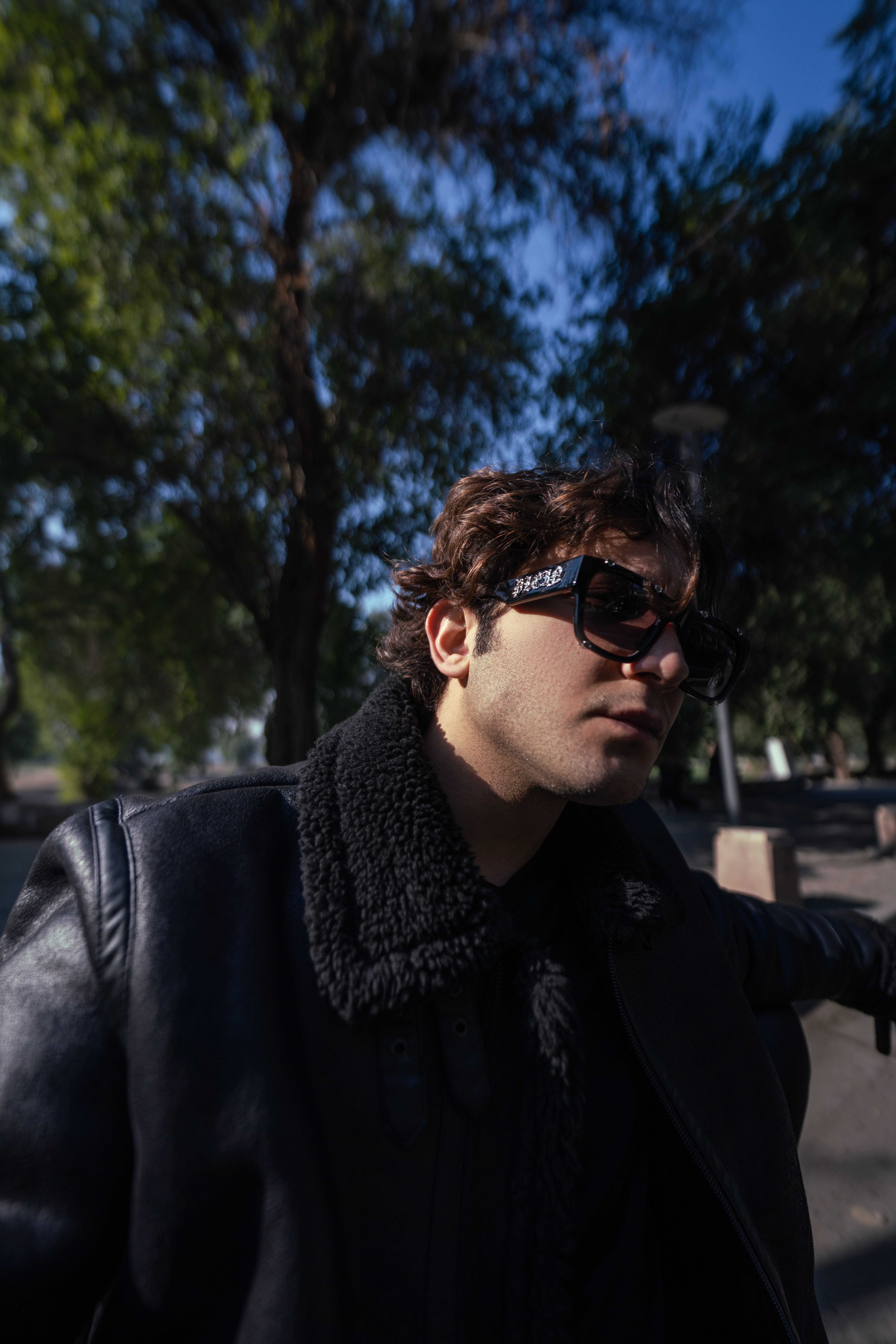 Portrait of a fashionable person wearing sunglasses outdoors in Baghdad.