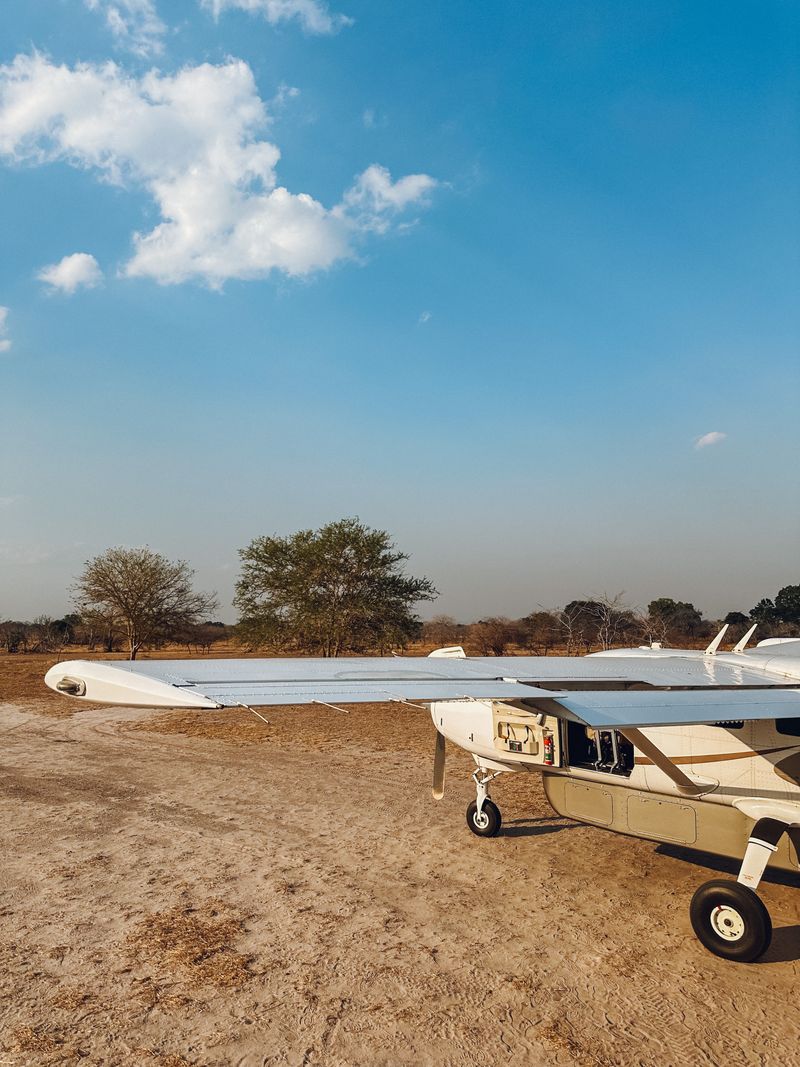 Small bush plane parked on a dirt airstrip in the African savannah