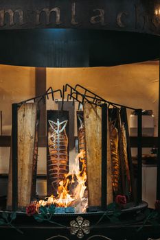 Grilled fish cooked on an open flame, showcasing traditional culinary methods with a rustic touch.