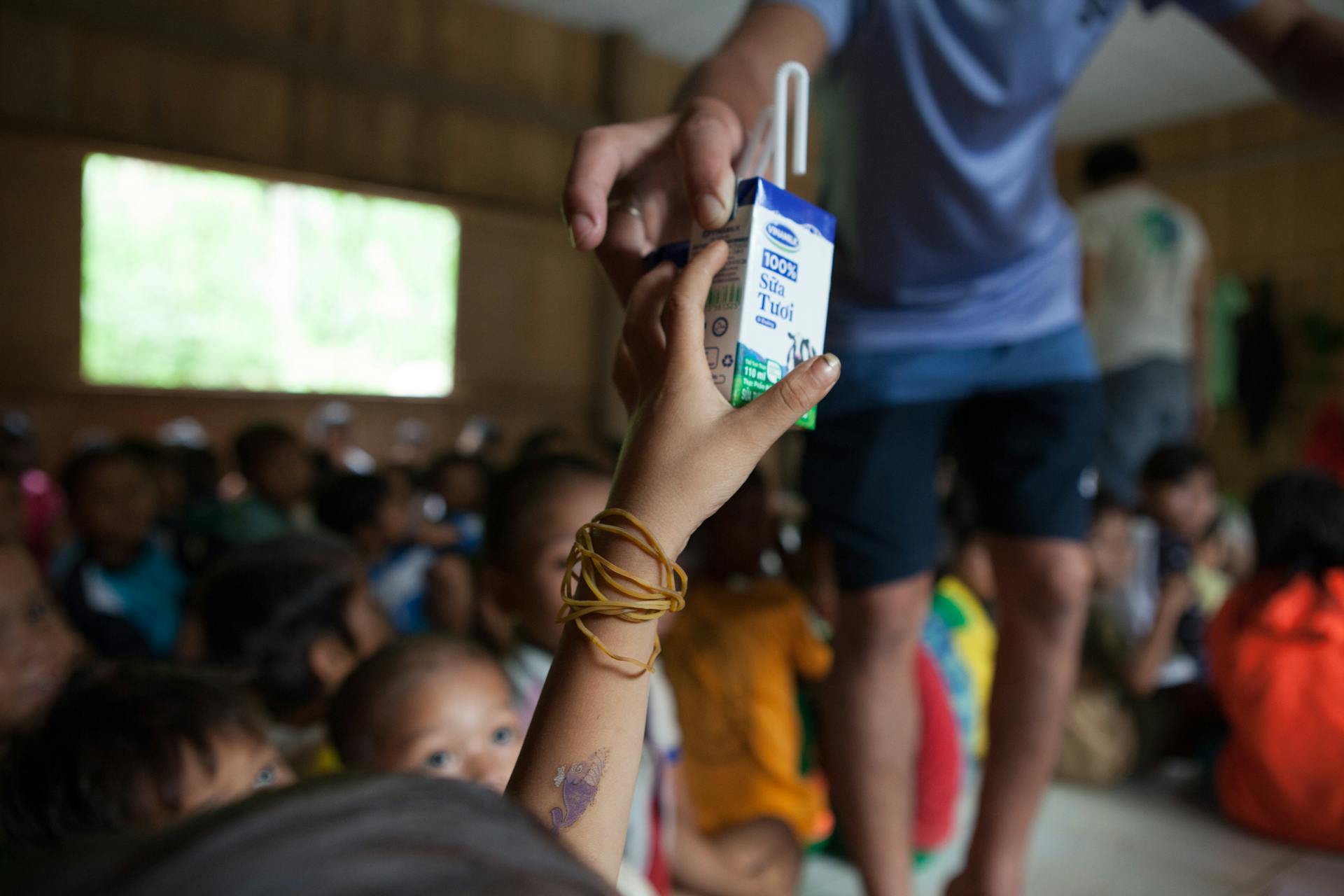 A Person Handing a Milk Carton