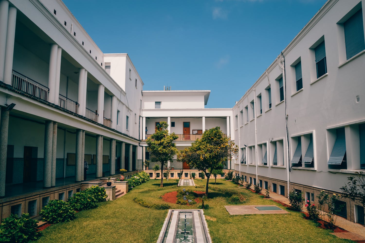 Elegant university building with garden courtyard under clear sky