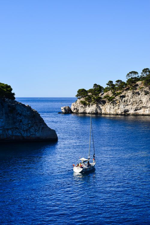 Free A sailboat navigating the clear blue waters of Calanques National Park in France. Stock Photo