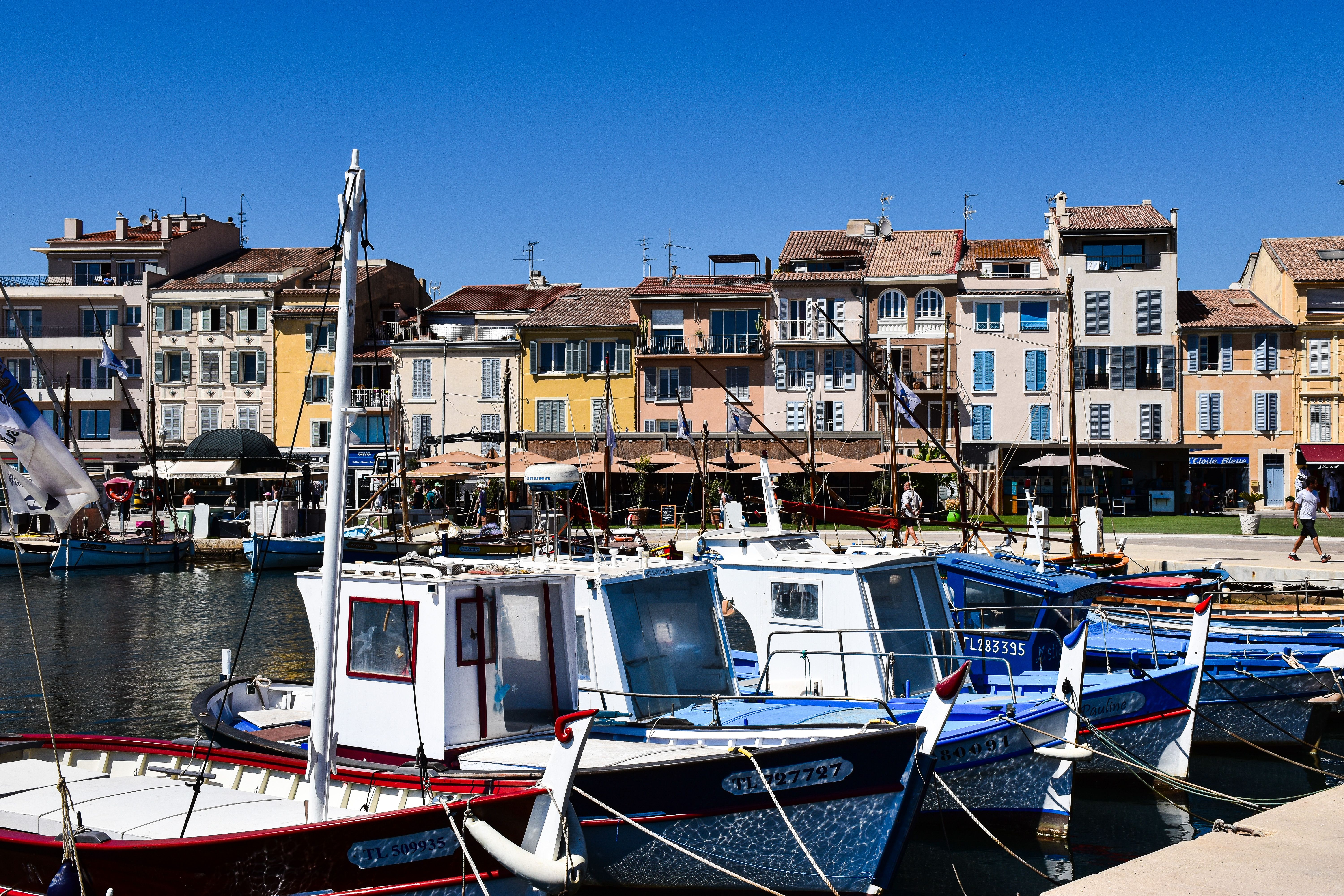 Colorful boats and buildings in Cassis port, Provence, France under clear skies. Colorful boats and buildings in Cassis port, Provence, France under clear skies.