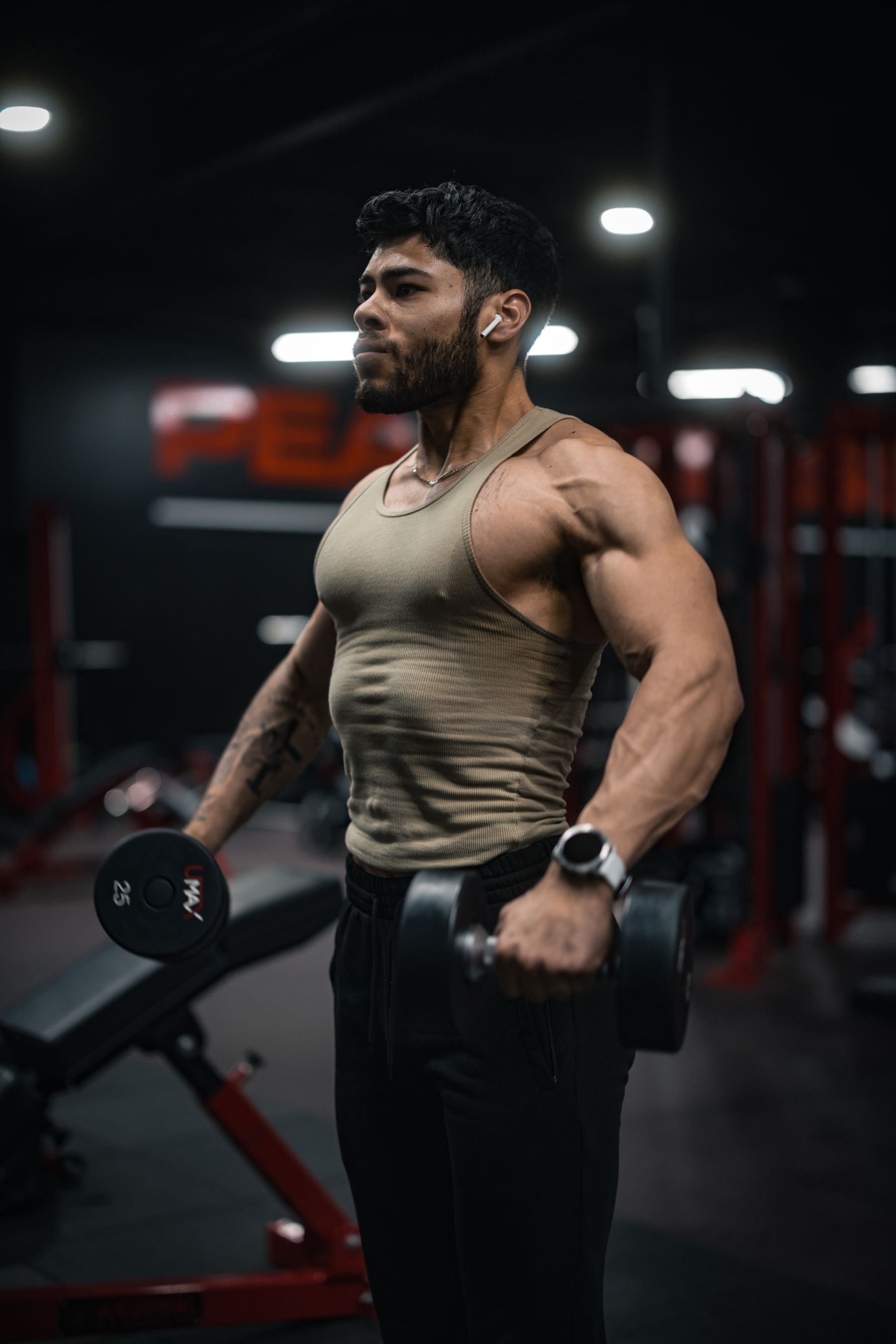 Athlete performing dumbbell strength training in a modern gym with training equipment visible