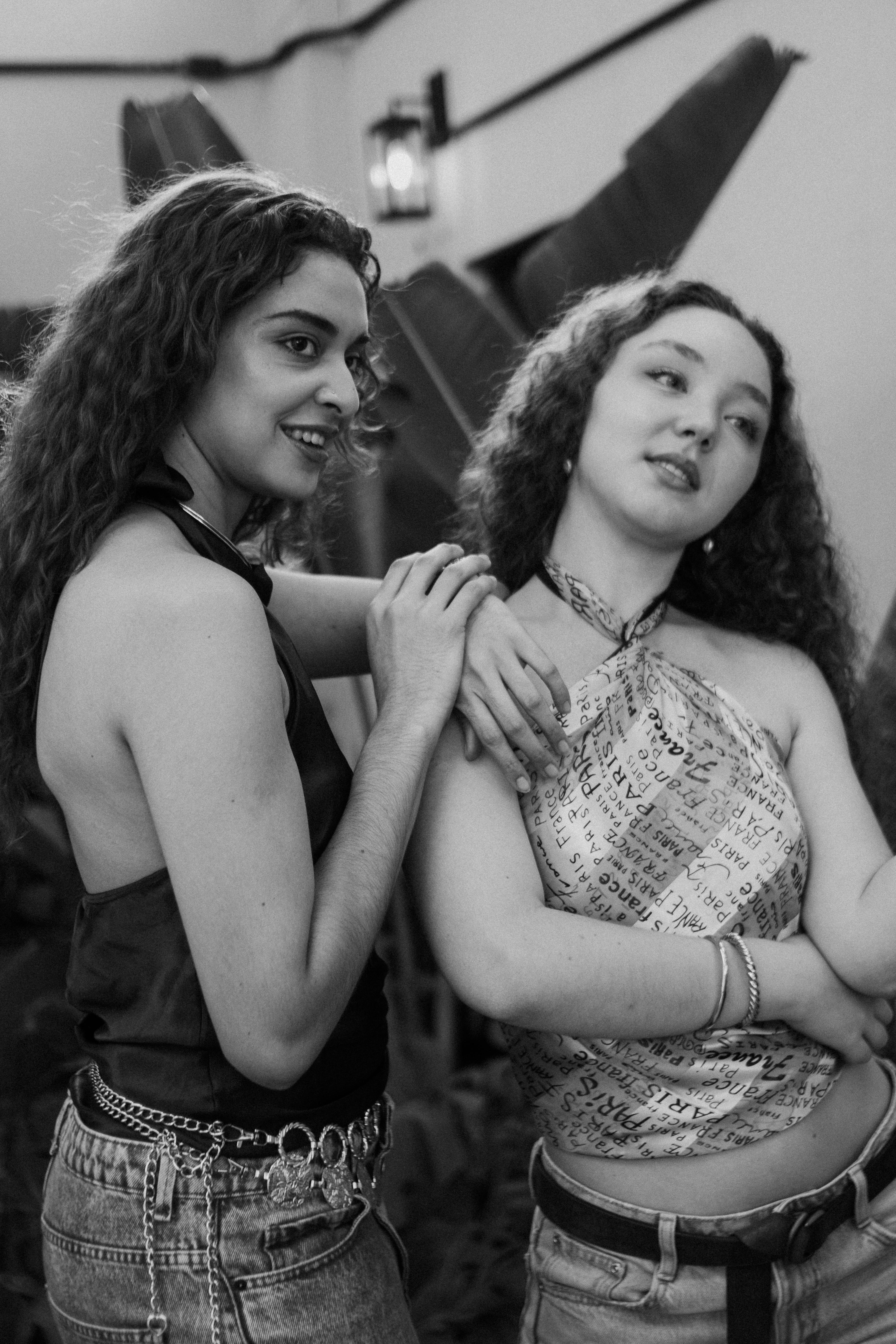 Two young adults enjoying a relaxed moment indoors, captured in monochrome.