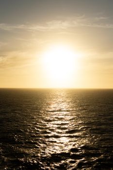 Captivating sunset casting golden hues over a vast and tranquil ocean horizon.