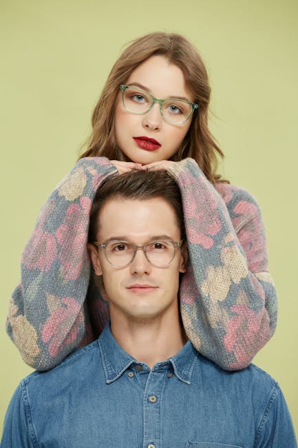 A fashionable couple wearing eyeglasses in a vibrant portrait setting.