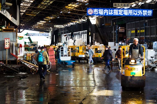 Lively scene at a Tokyo wholesale market featuring carts and transport vehicles.