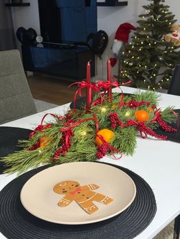 Cozy holiday table setting with Christmas decorations and gingerbread-themed plate.