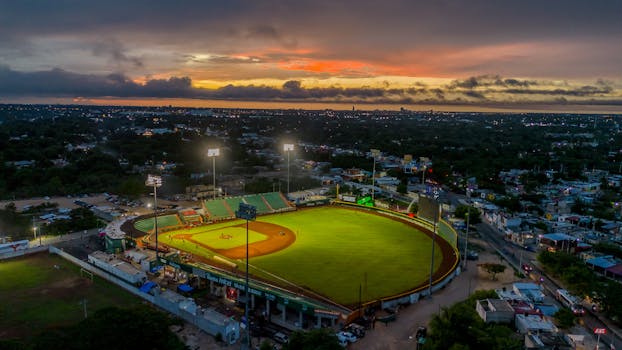 A stunning aerial view of a baseball stadium in Kanasín, México during sunset, capturing the vibrant atmosphere.