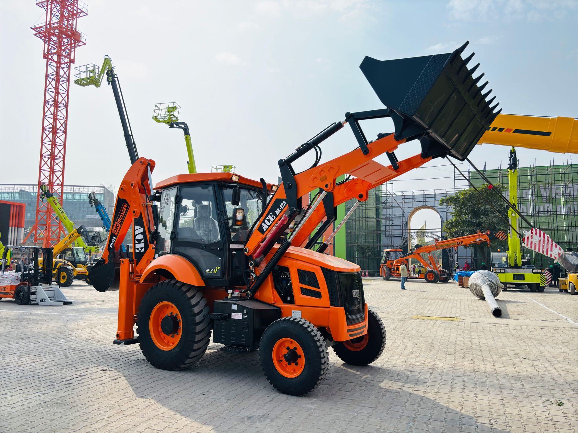 Colorful ACE AX 124 backhoe loader on display in an Indian construction area. Perfect sunlit shot.