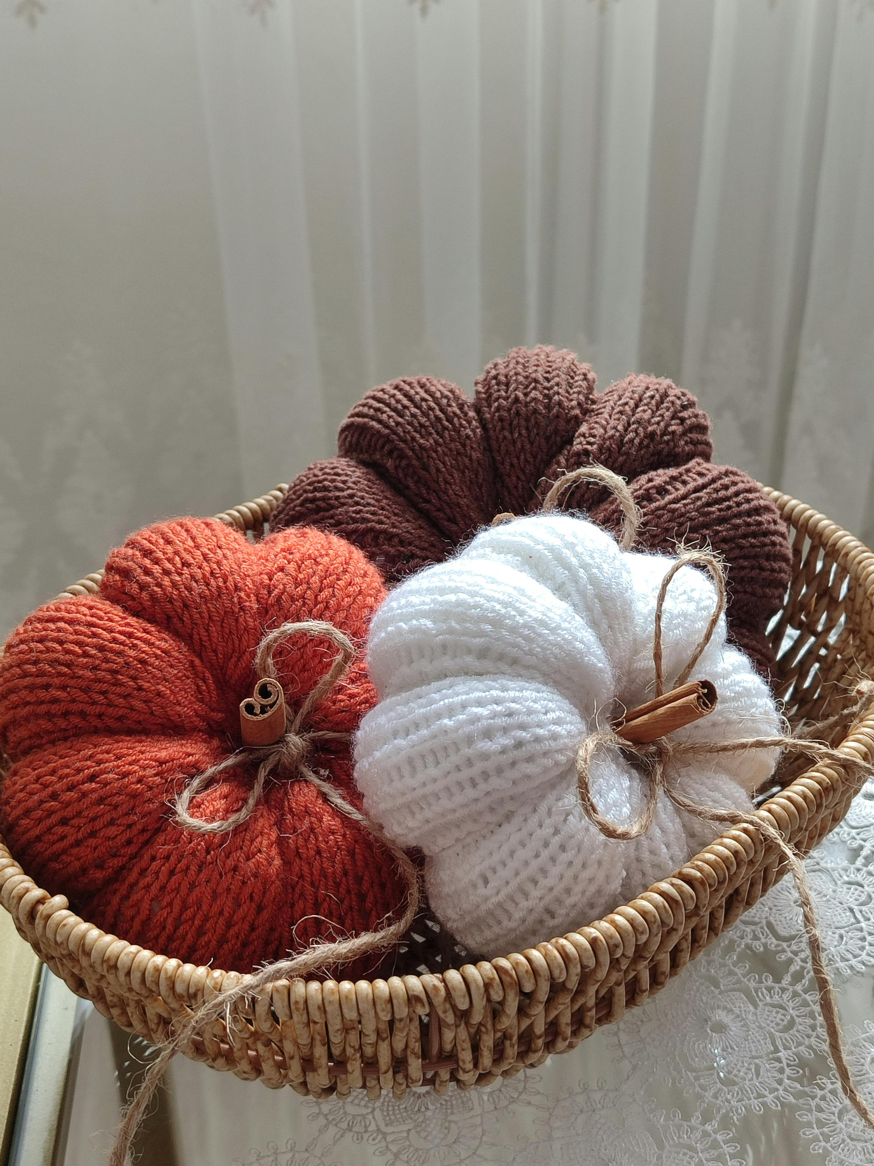 Warm knitted pumpkins in autumn colors, perfect for rustic fall decor.