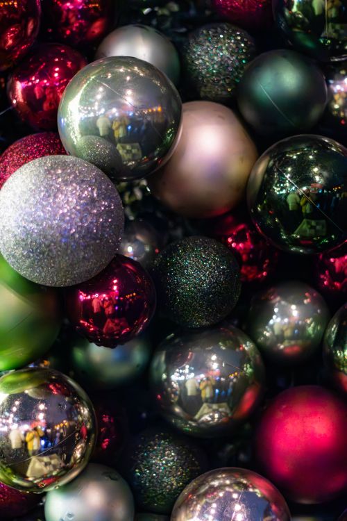 Free Colorful Christmas baubles arranged in a festive setting with sparkling lights. Stock Photo