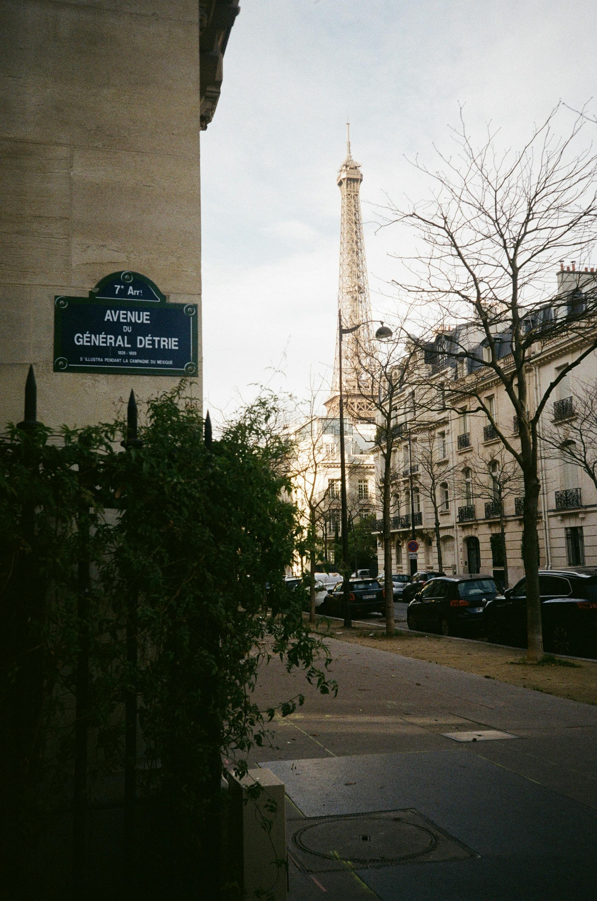 Classic Paris street scene with Eiffel Tower view from Avenue Général Détrie, capturing urban charm.