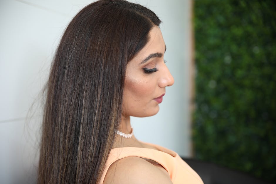 Profile portrait of an elegant woman with long hair and pearl necklace.