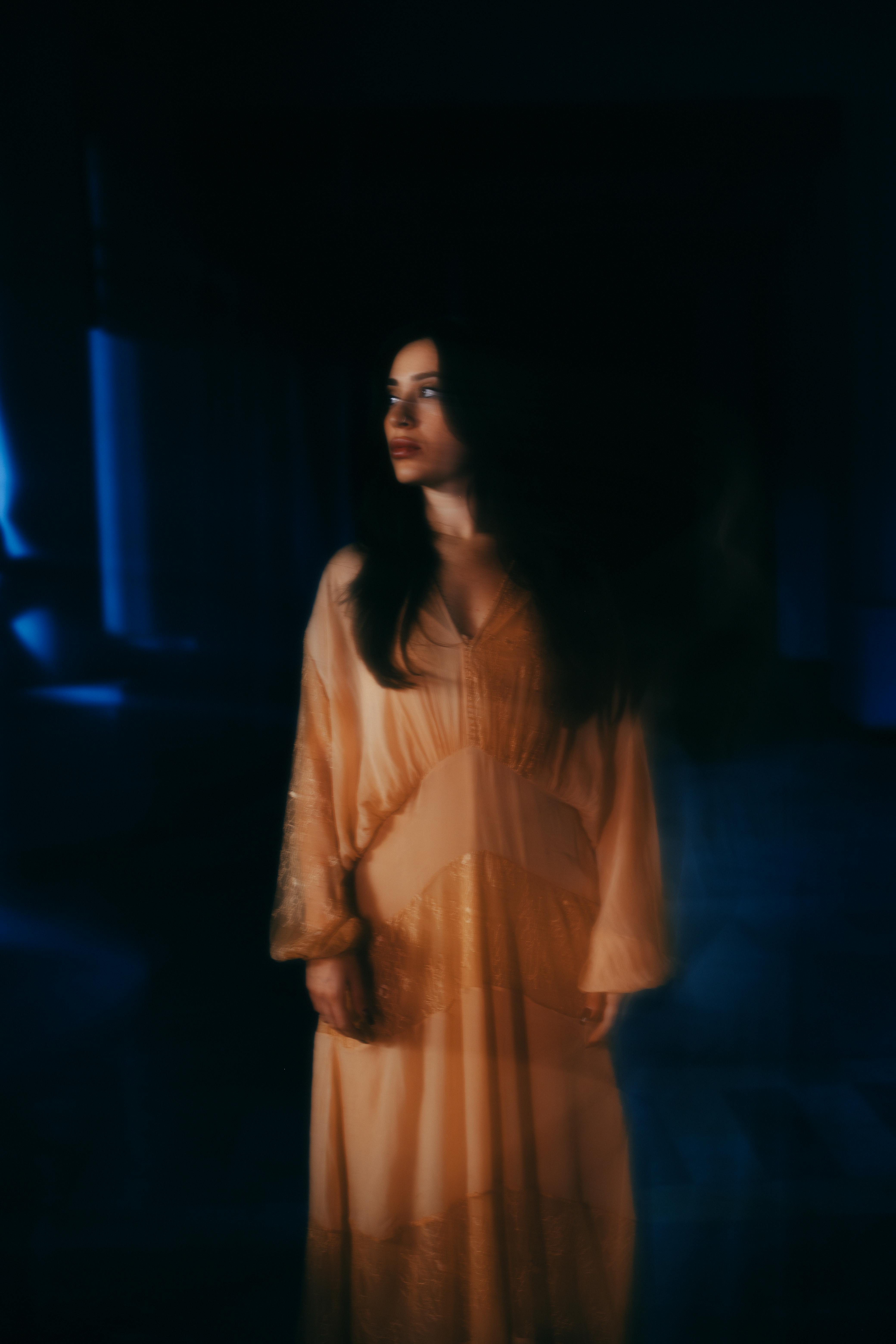 An ethereal portrait of a woman in a flowing dress, exuding a mysterious and dreamlike mood.