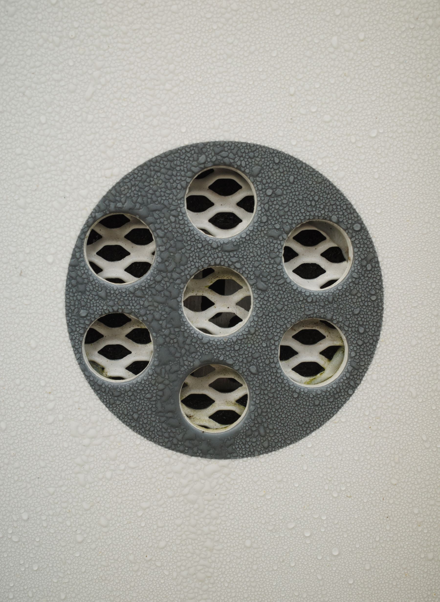 Close-up of a wet metal floor drain