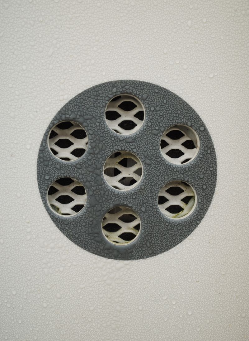 Close-up of a wet metal floor drain