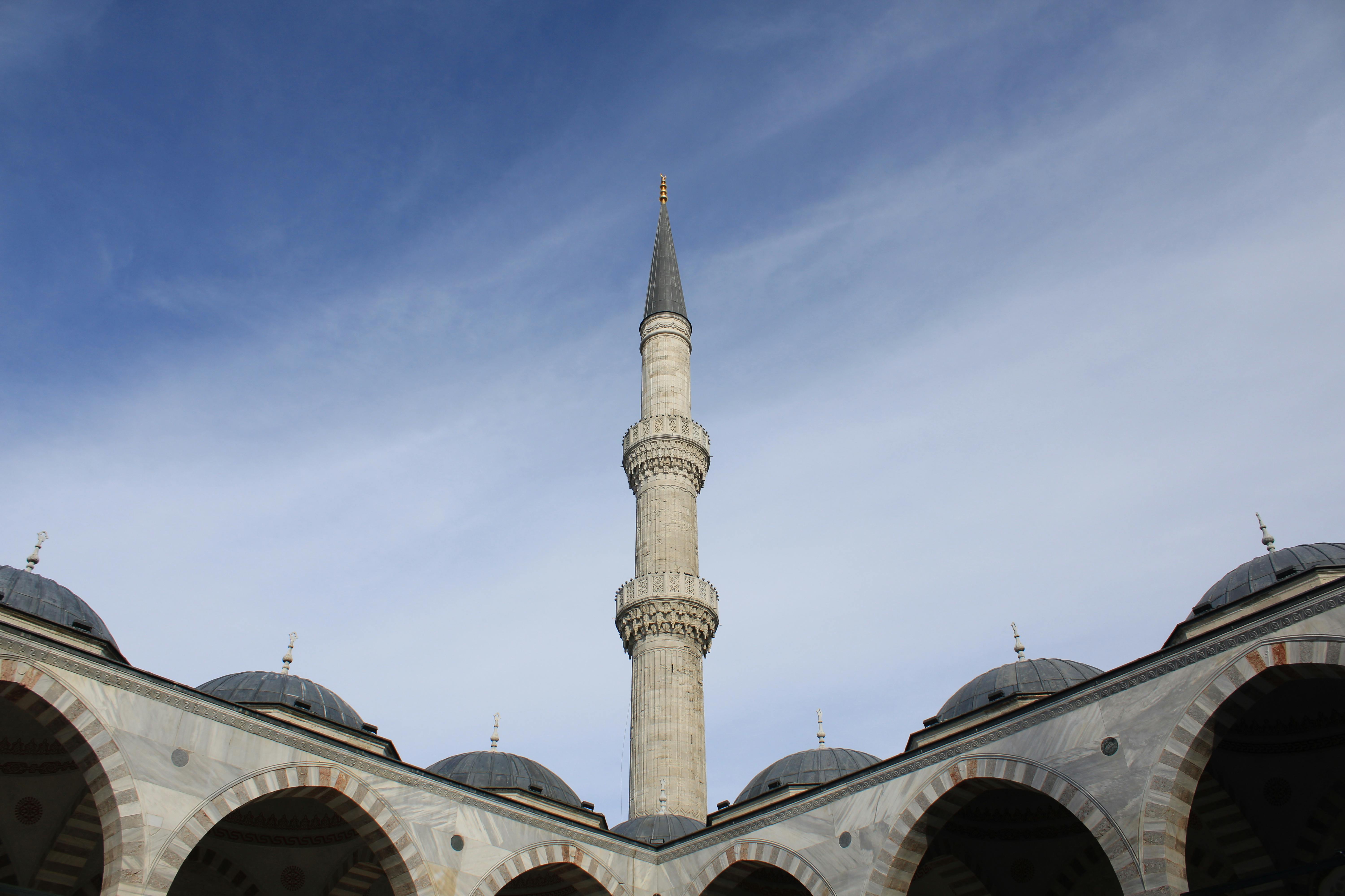 View of a mosque minaret reaching into the blue sky in Istanbul, showcasing Islamic architecture. - Estambul