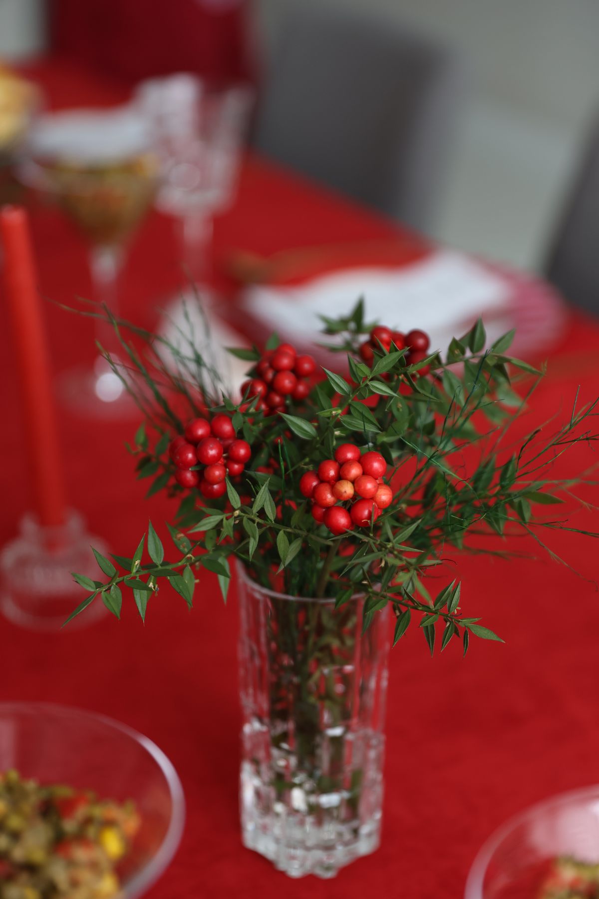 Red berry branches in a glass vase as a Christmas centerpiece