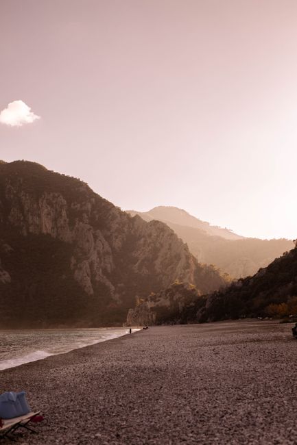 Calm evening beach scene with mountains in the background, ideal for travel and nature themes.