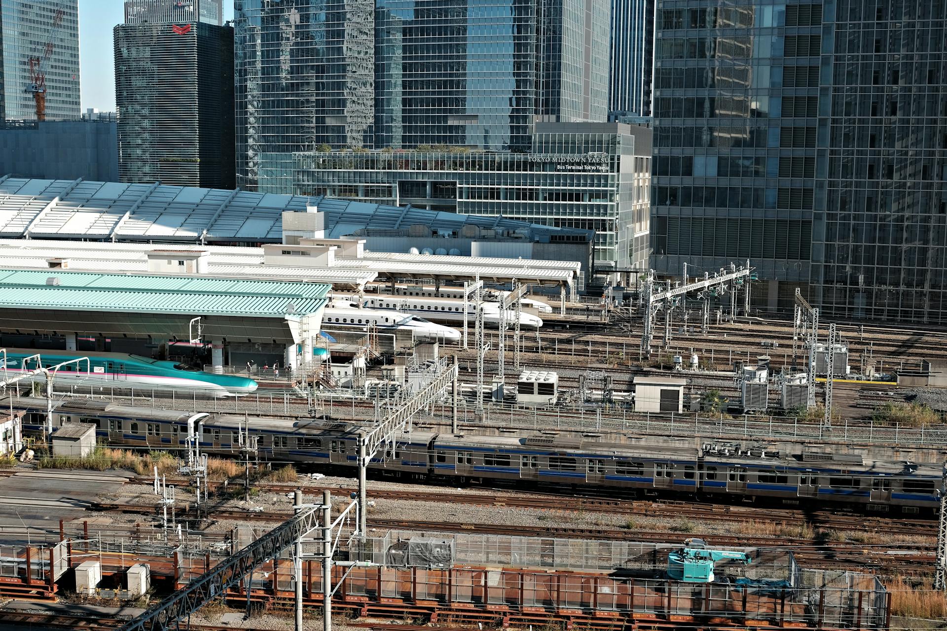 Tokyo train station with modern skyscrapers and Shinkansen trains representing efficient public transportation.