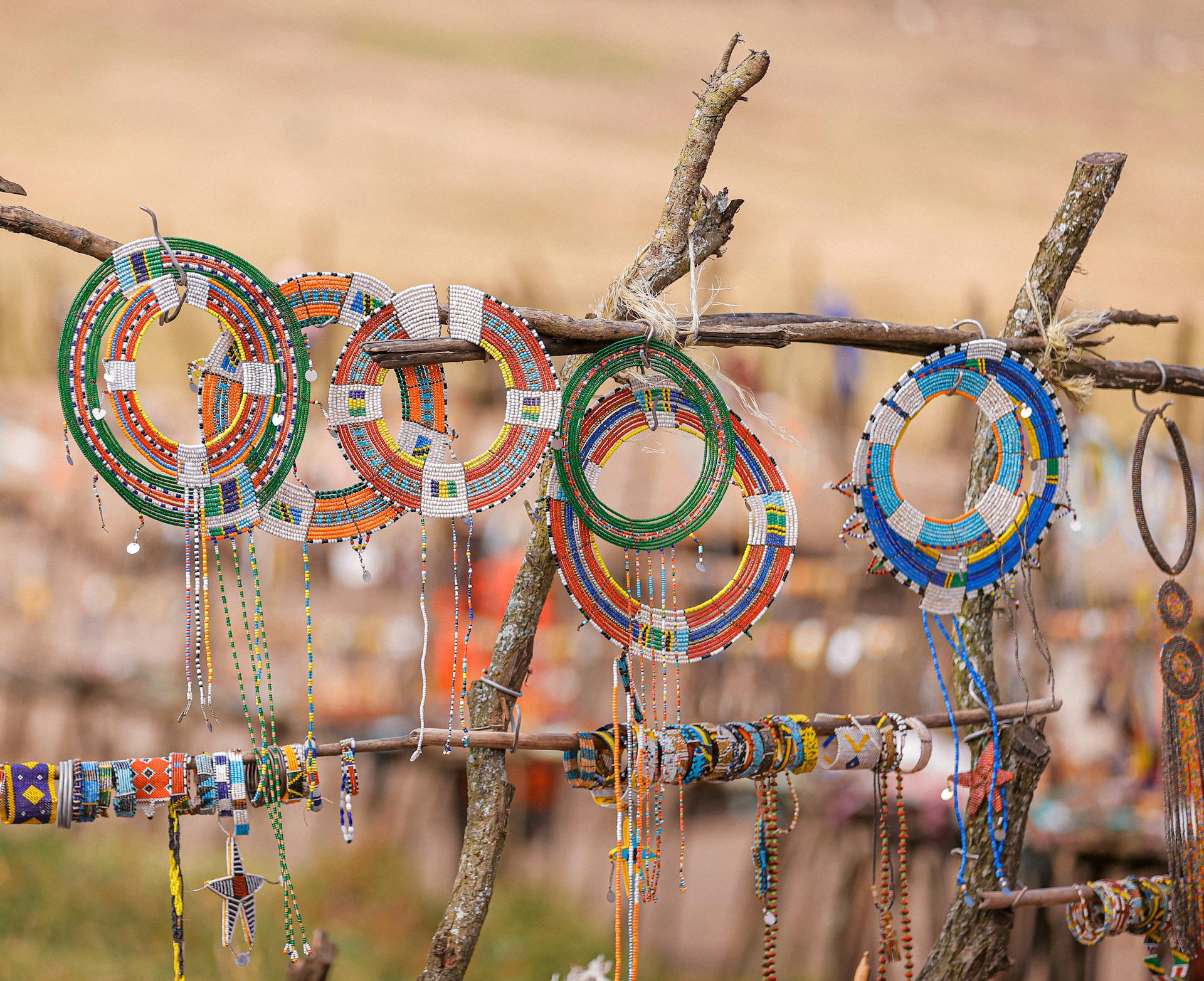 Vibrant Maasai beaded jewelry displayed on wooden racks in Ngorongoro, Tanzania.