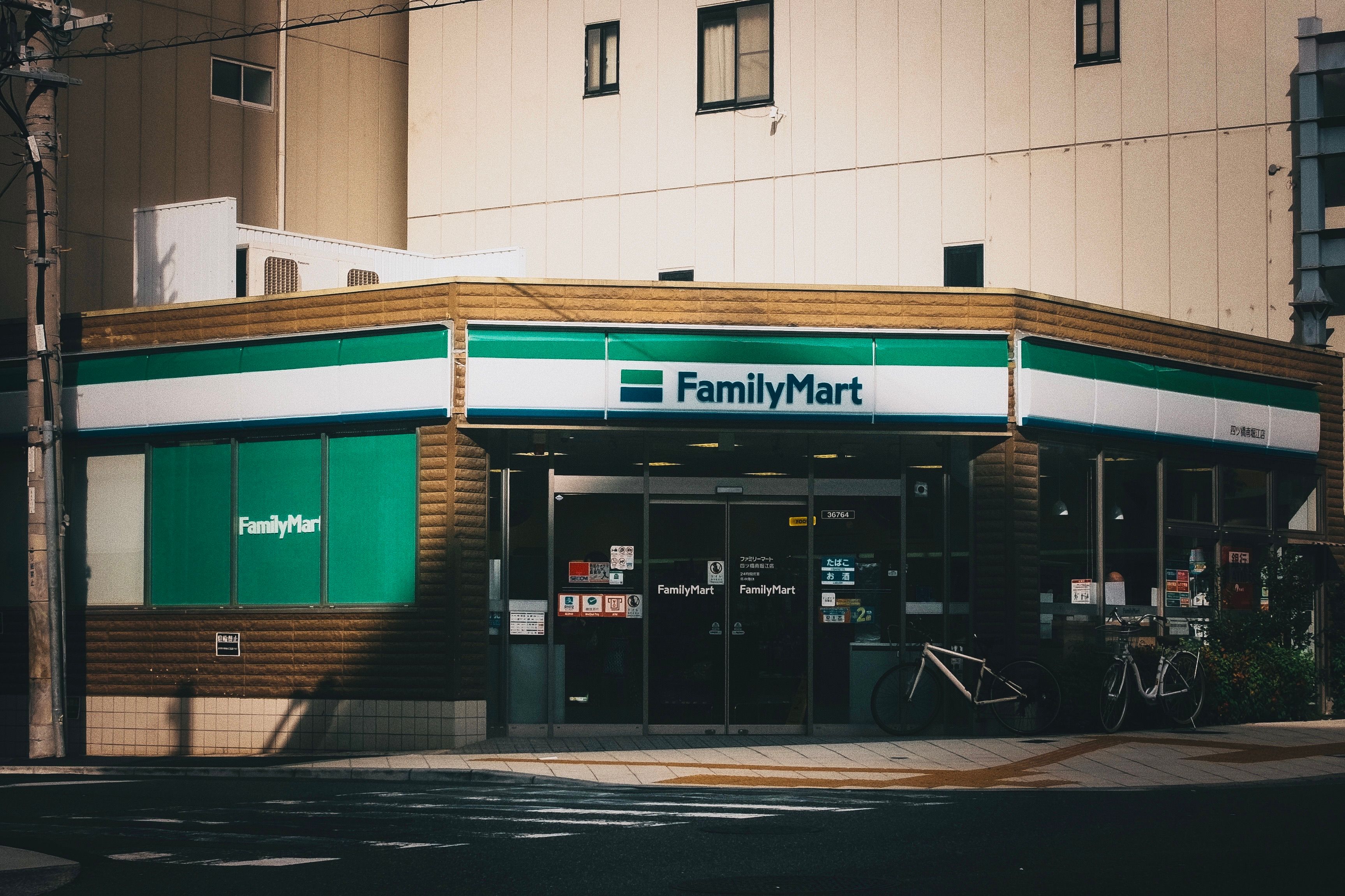 Outdoor view of a FamilyMart convenience store with bicycles parked outside.
