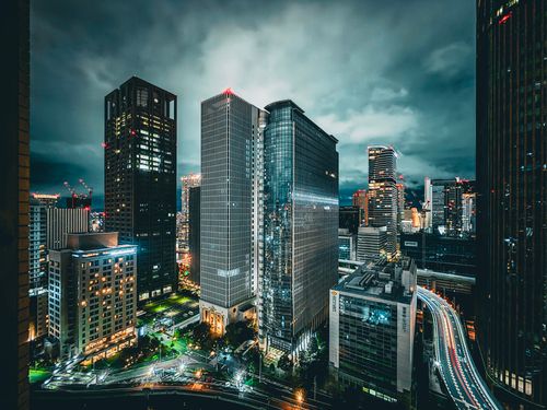 Free Vibrant city skyline illuminated at night, highlighting tall skyscrapers and busy highways. Stock Photo