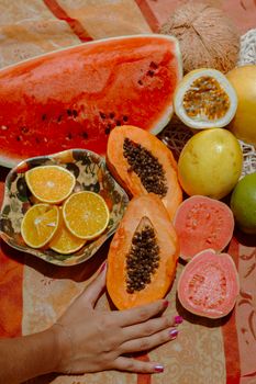 Vibrant tropical fruits including watermelon, papaya, and guava set on a sunny summer background.
