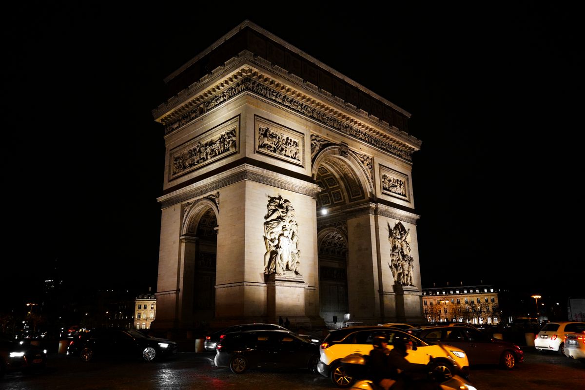 The Arc de Triomphe illuminated at night with car light trails on the Champs-Élysées