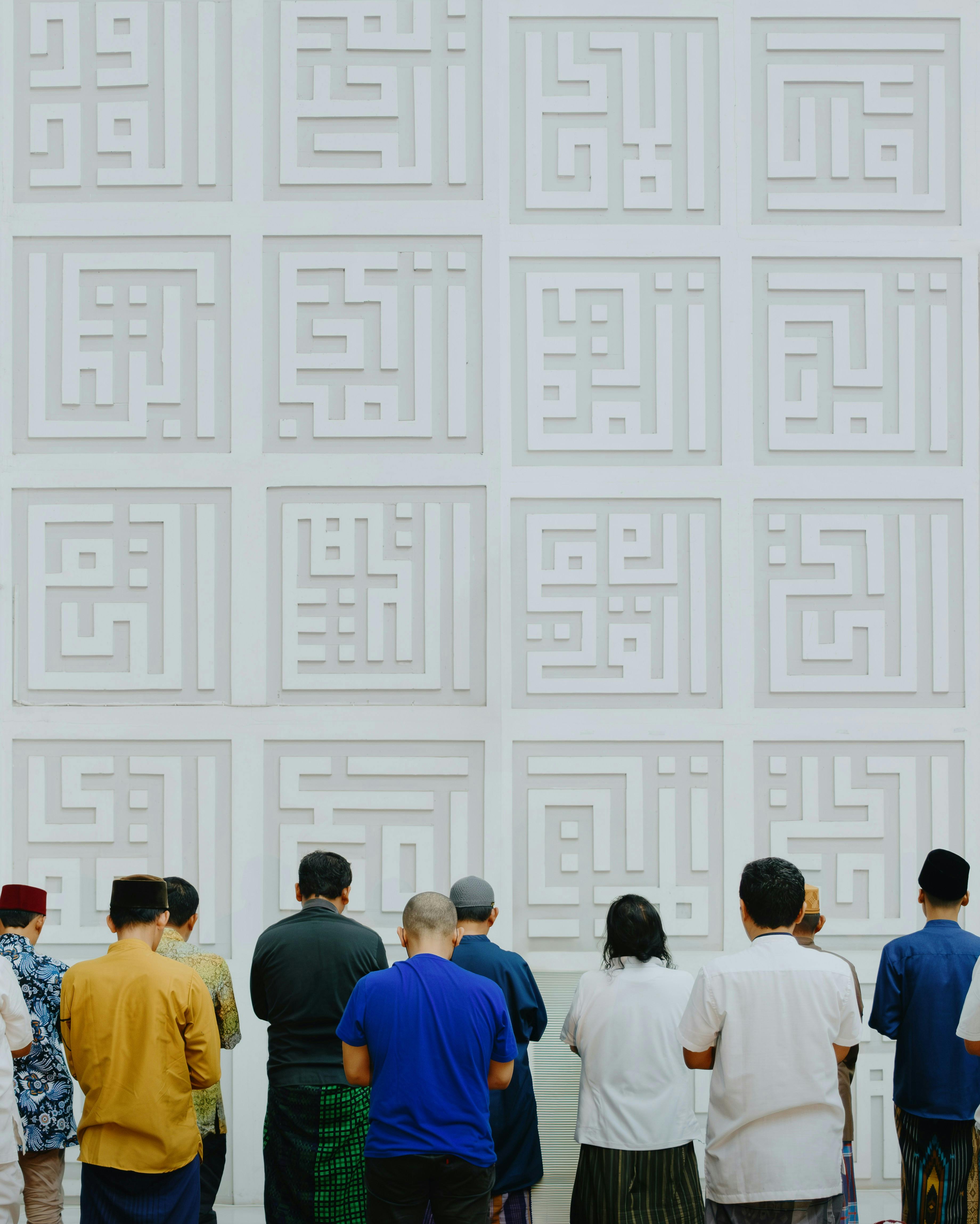 A group of Indonesian Muslims performing prayer inside a modern mosque with geometric design.