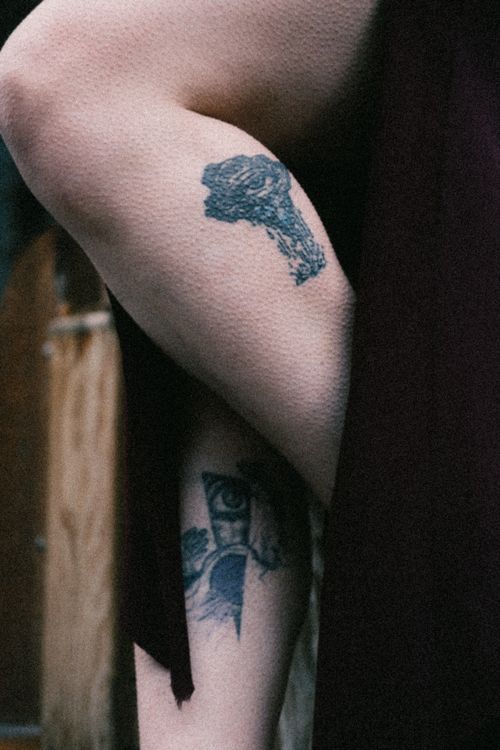 Free Close-up of tattoos on a person's leg showing artistic designs in an urban background. Stock Photo