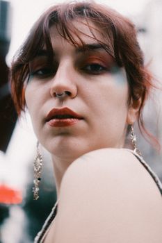 Artistic portrait of a young woman with jewelry, captured outdoors.