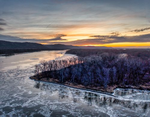 Free Beautiful aerial shot of a frozen river with a vibrant sunset in West Newton, Minnesota. Stock Photo