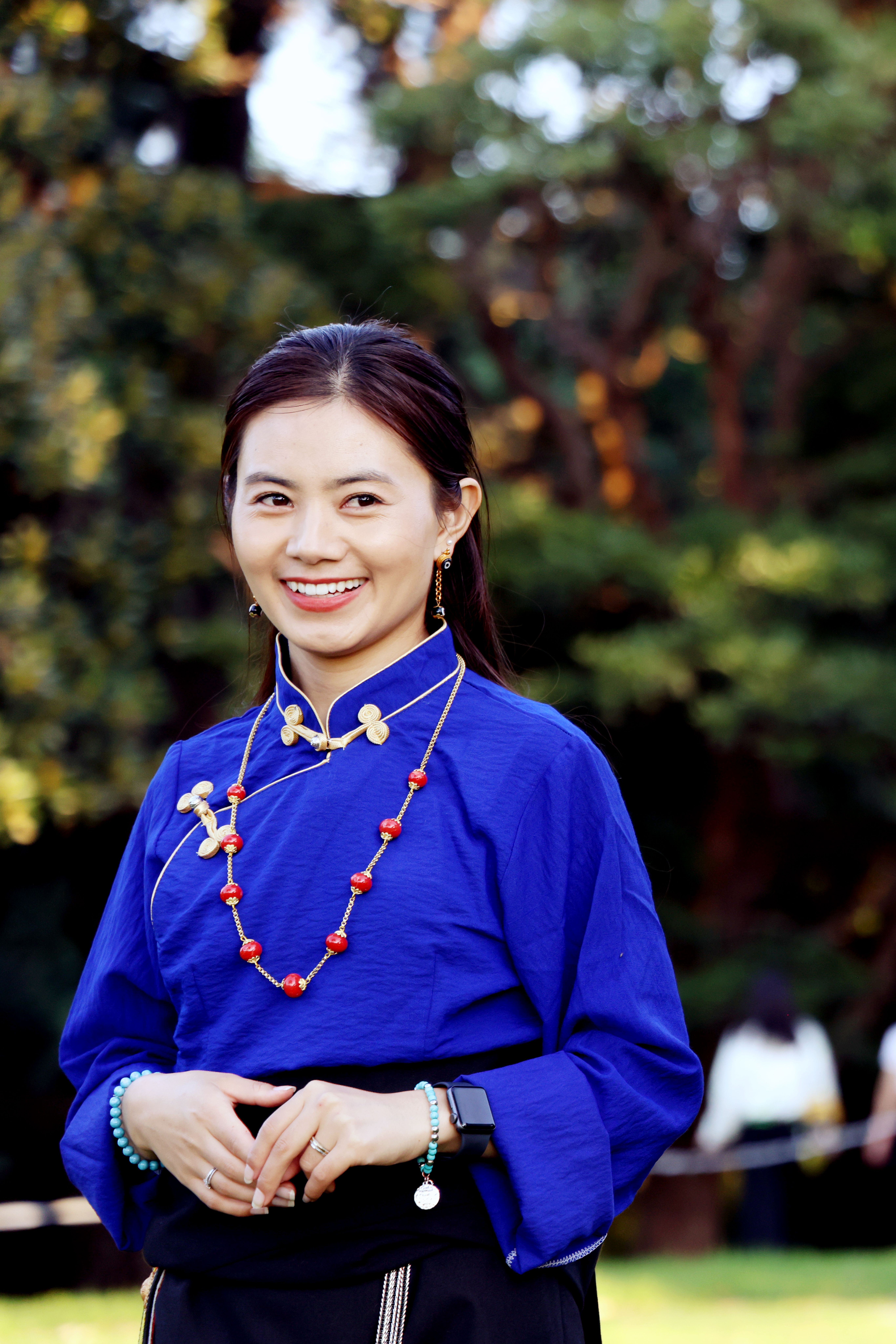 Smiling Woman in Traditional Blue Attire Outdoors · Free Stock Photo
