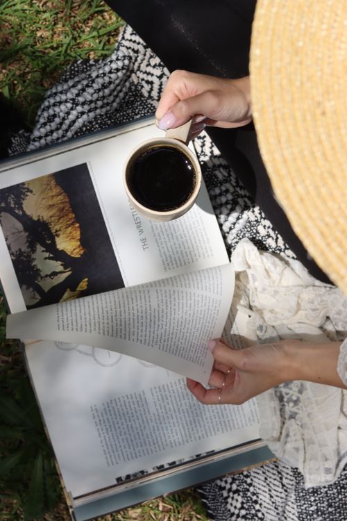 Free Relaxing outdoors with a book and coffee under natural light. Stock Photo